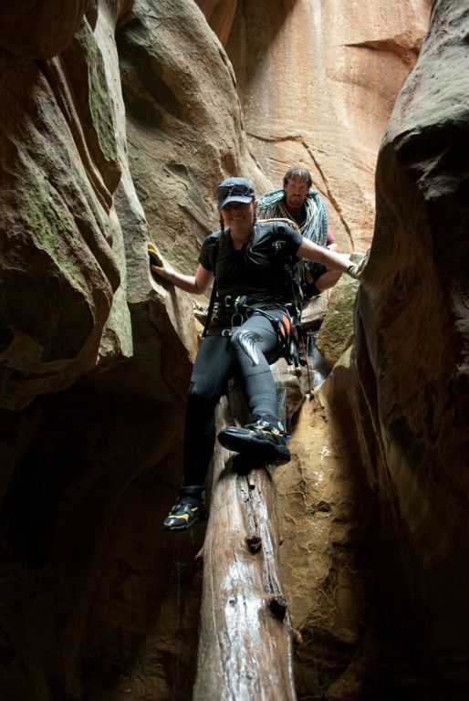 Cami Pulham and Andrew McKinney climbing down a log in Boundary Canyon