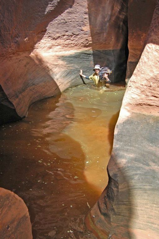 Tim wading through the large pothole in Baker Canyon