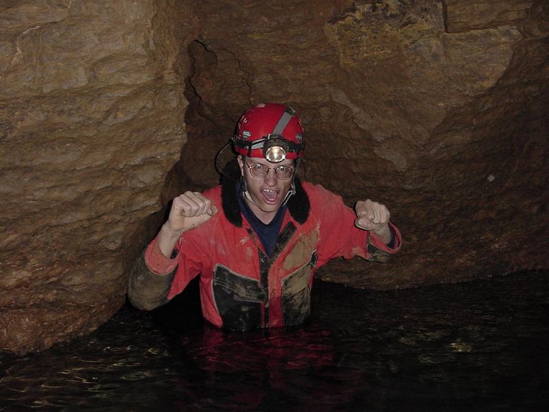 Rob Cranney at the stream passage's end in Logan Cave.