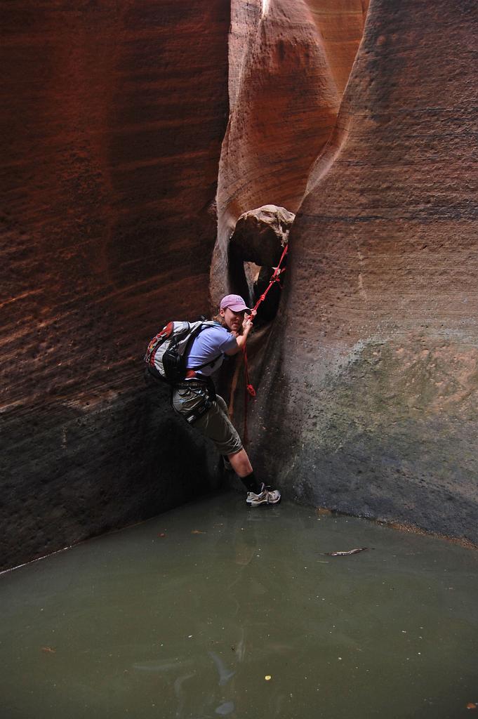 Rachael Keske climbing webbing to pool in Keyhole Canyon.