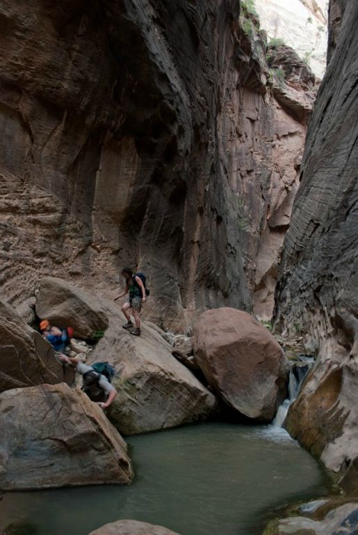 Chad Utterback falling into pool in Orderville Canyon with Megan Porter and Kate Feller following.